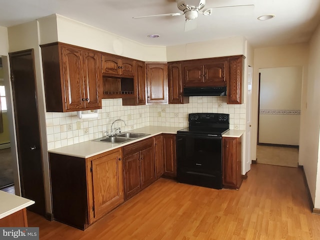 kitchen with sink, backsplash, ceiling fan, black range with electric cooktop, and light hardwood / wood-style flooring