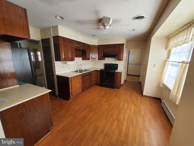 kitchen with sink, black appliances, light wood-type flooring, ceiling fan, and a baseboard heating unit