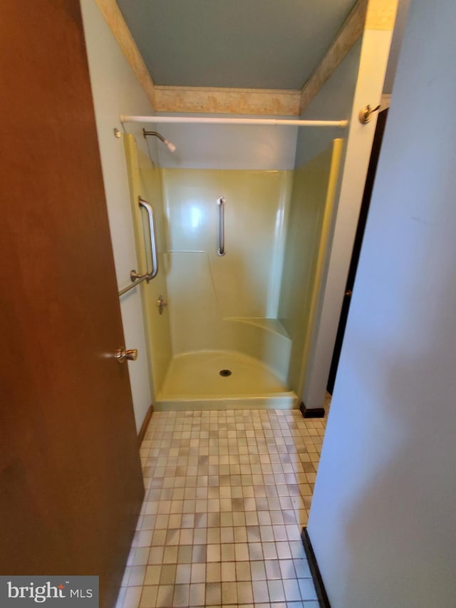 bathroom featuring ornamental molding and walk in shower