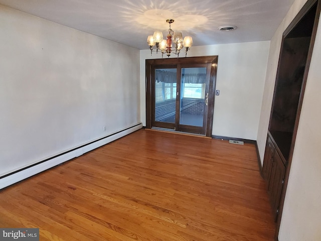 unfurnished dining area with an inviting chandelier, a baseboard heating unit, and light hardwood / wood-style floors