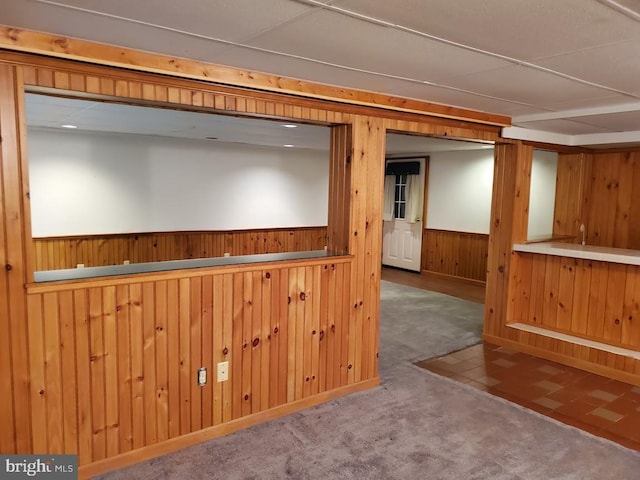 interior space featuring carpet and wood walls