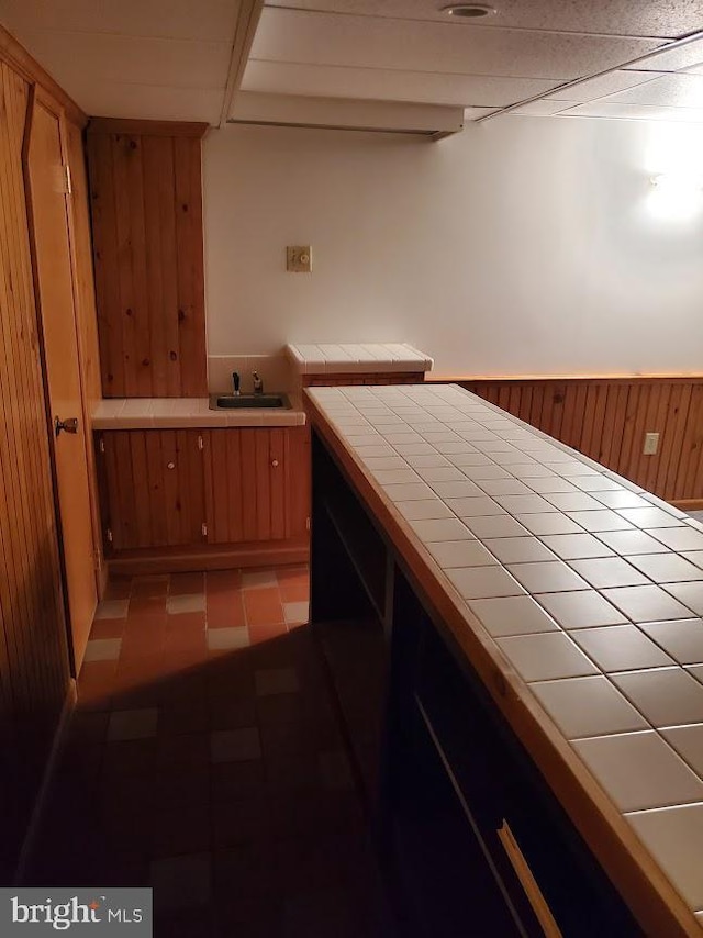 unfurnished bedroom featuring sink and wooden walls