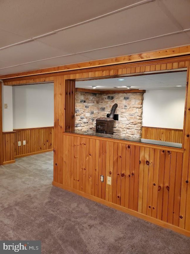 basement with light colored carpet and wood walls