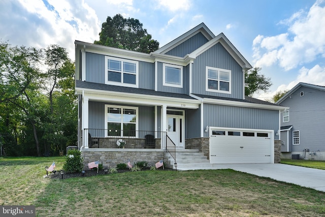 craftsman-style home featuring covered porch, a garage, and a front yard