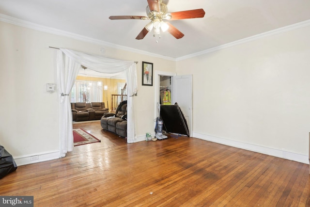 empty room featuring hardwood / wood-style flooring, ceiling fan, and crown molding