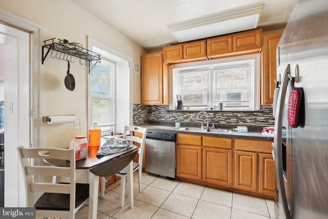 kitchen featuring decorative backsplash, appliances with stainless steel finishes, light tile patterned floors, and sink