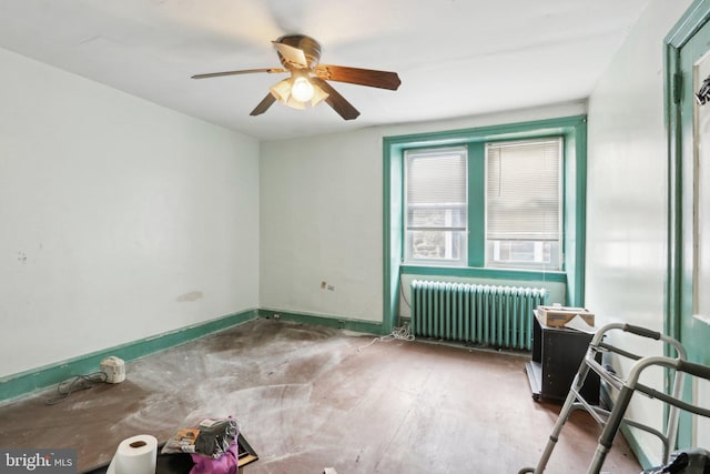 unfurnished room featuring ceiling fan and radiator heating unit