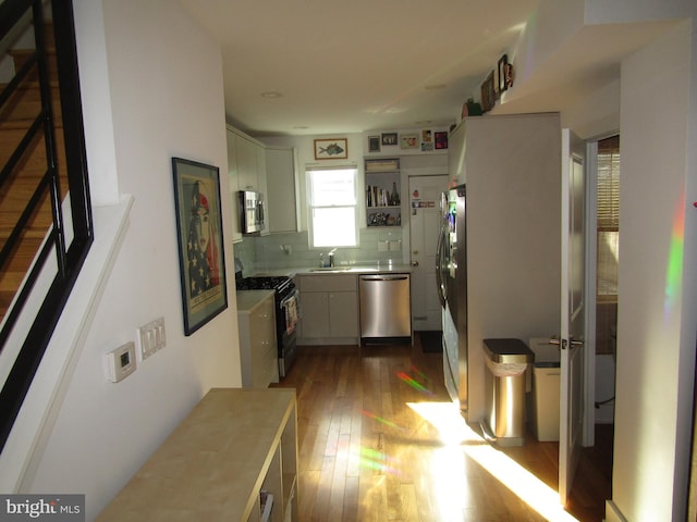 kitchen with tasteful backsplash, sink, dark wood-type flooring, and appliances with stainless steel finishes