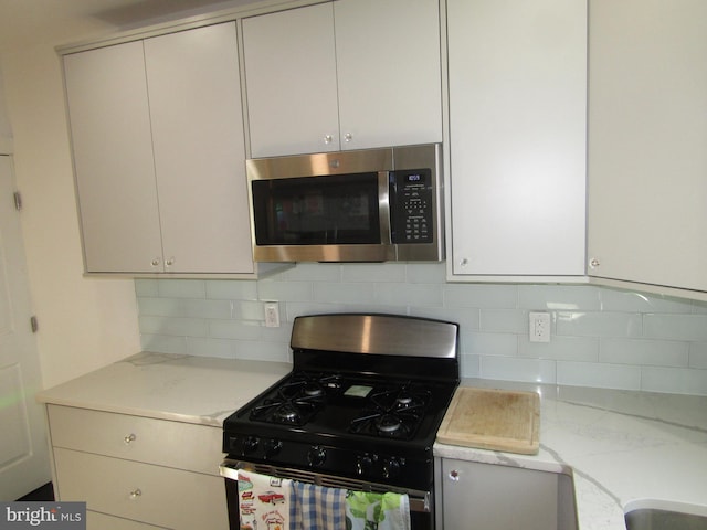 kitchen with tasteful backsplash, light stone countertops, and stainless steel appliances