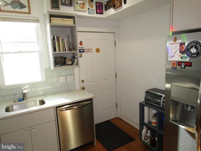 kitchen featuring backsplash, dark hardwood / wood-style floors, sink, and stainless steel appliances