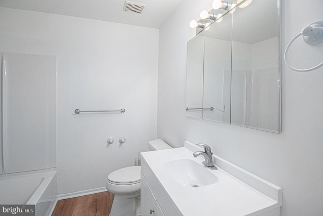 bathroom featuring vanity, wood-type flooring, and toilet