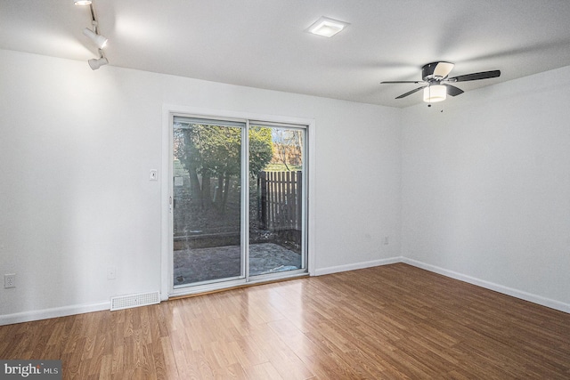 unfurnished room featuring hardwood / wood-style floors, ceiling fan, and track lighting