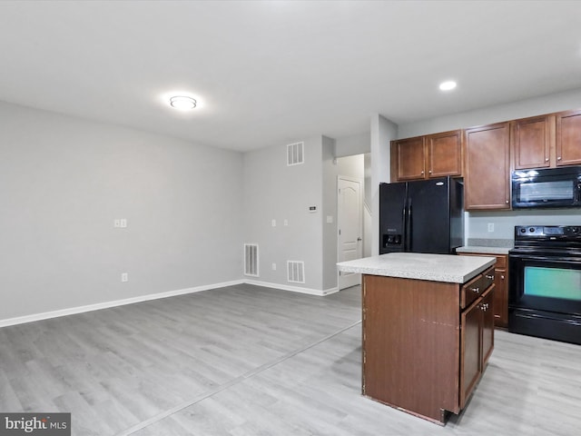 kitchen with a center island, light hardwood / wood-style flooring, and black appliances