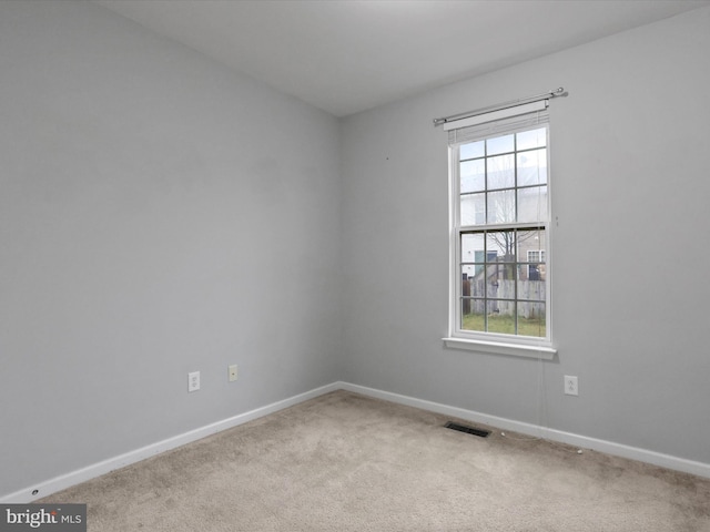 empty room with carpet floors and a wealth of natural light