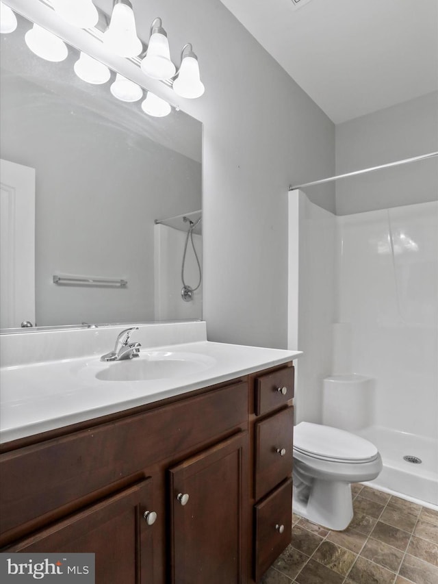 bathroom featuring vanity, toilet, and walk in shower