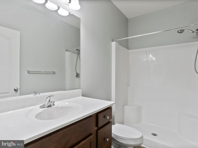 bathroom featuring vanity, toilet, and walk in shower