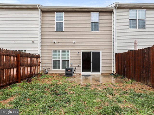 rear view of property with a patio, cooling unit, and a lawn