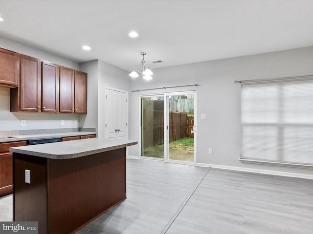 kitchen with dishwashing machine, a notable chandelier, a center island, light hardwood / wood-style floors, and hanging light fixtures