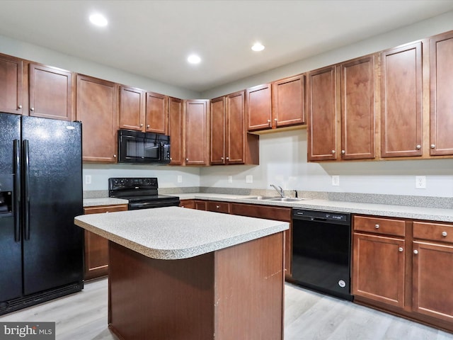 kitchen with sink, light hardwood / wood-style floors, a kitchen island, and black appliances