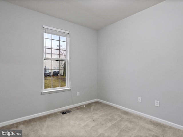 unfurnished room featuring light carpet