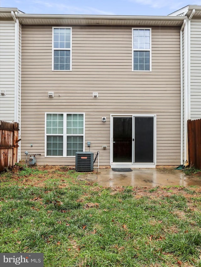 back of property featuring central AC, a patio area, and a yard