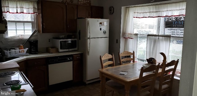 kitchen with sink, a healthy amount of sunlight, and white appliances