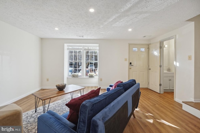 living room featuring wood-type flooring and a textured ceiling