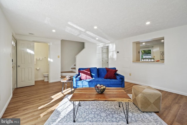 living room with hardwood / wood-style floors and a textured ceiling