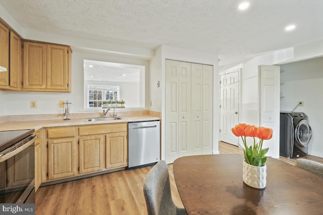 kitchen featuring sink, dishwasher, electric range oven, washing machine and dryer, and light hardwood / wood-style flooring