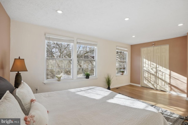 bedroom featuring a closet, wood-type flooring, and a textured ceiling