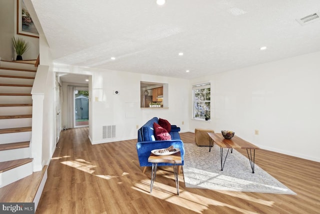 living room with hardwood / wood-style floors and a textured ceiling