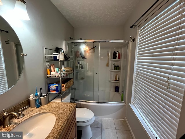 full bathroom with vanity, tile patterned flooring, toilet, enclosed tub / shower combo, and a textured ceiling