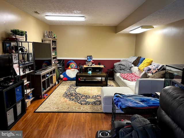 living room with wood-type flooring and a textured ceiling