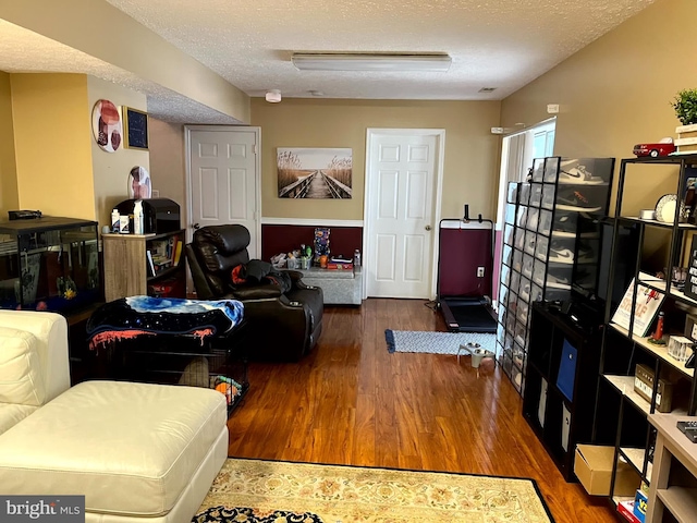 living area with wood finished floors and a textured ceiling