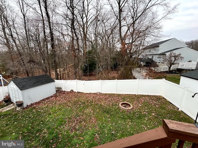 view of yard featuring a storage shed and an outdoor fire pit