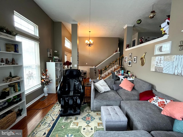 living room with stairs, an inviting chandelier, and wood finished floors