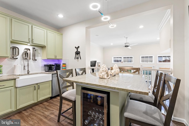 kitchen with wine cooler, green cabinets, and a breakfast bar area