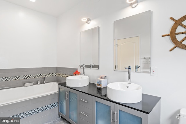 bathroom with vanity and a relaxing tiled tub