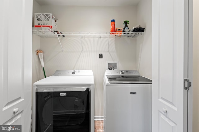 laundry area with hardwood / wood-style floors and washing machine and dryer