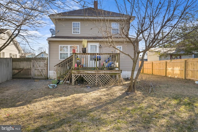 rear view of property featuring a yard and a wooden deck