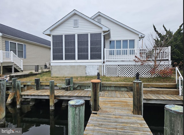 back of house with a sunroom and a wooden deck