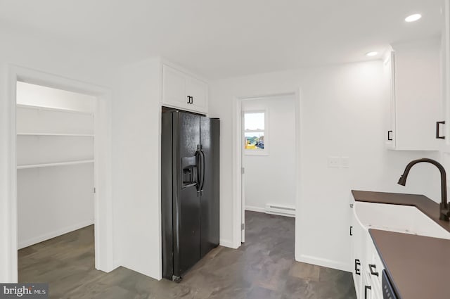 kitchen with white cabinets, black refrigerator with ice dispenser, and a baseboard radiator