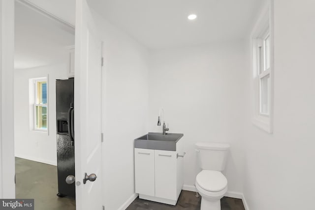 bathroom featuring plenty of natural light, vanity, and toilet