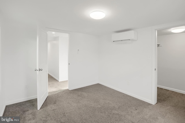 empty room featuring a wall mounted air conditioner and carpet flooring