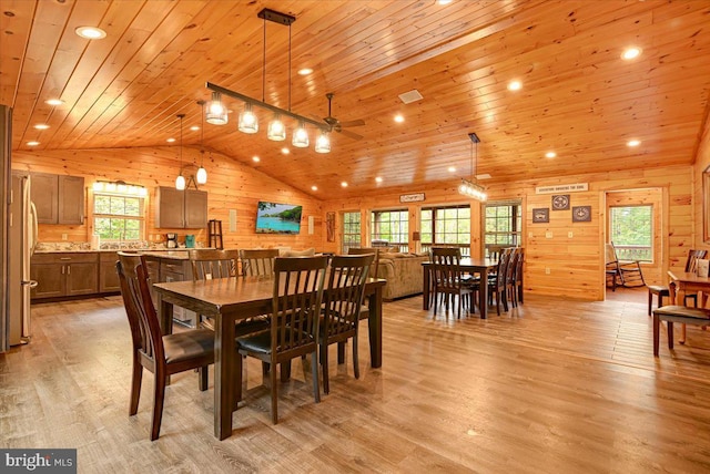 dining room with wood walls, plenty of natural light, light hardwood / wood-style floors, and wooden ceiling