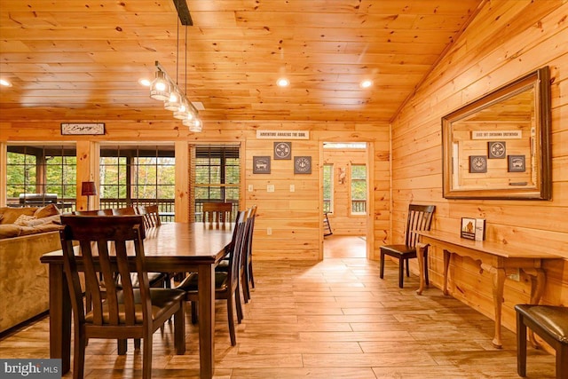 dining area featuring wood walls, light hardwood / wood-style floors, lofted ceiling, and wood ceiling