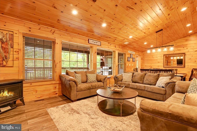 living room featuring light hardwood / wood-style flooring, vaulted ceiling, wood walls, and wood ceiling