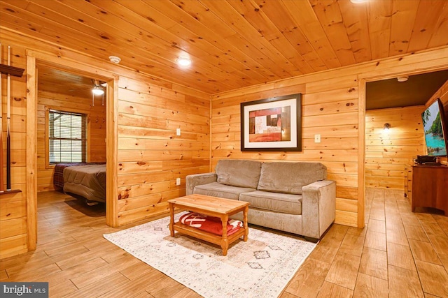 living room with light wood-type flooring, wood ceiling, and wood walls