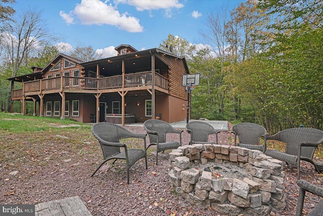 rear view of house with a deck and an outdoor fire pit