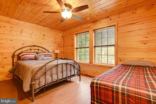 bedroom featuring hardwood / wood-style floors, ceiling fan, wooden walls, and wood ceiling